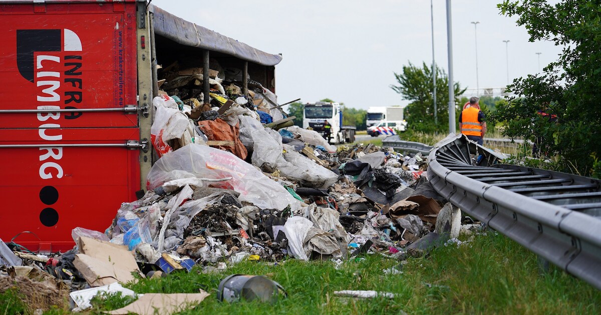 Chaos op A58 door gekantelde vrachtwagen vol met afval, schermen geplaatst vanwege kijkersfile.