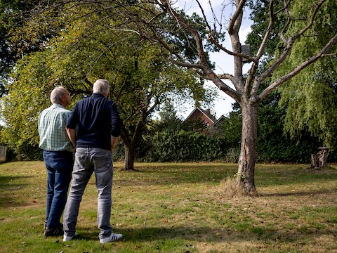 Johan Kemperink (links) en Gerard Wolf in de tuin van Gerard, waar een appelboom op sterven na dood is door de droogte.