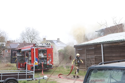 Veel rook bij uitslaande brand in loods achter woningen in Nijverdal