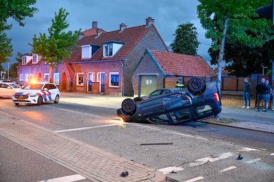 Auto komt op de kop terecht na botsing, bestuurder aangehouden