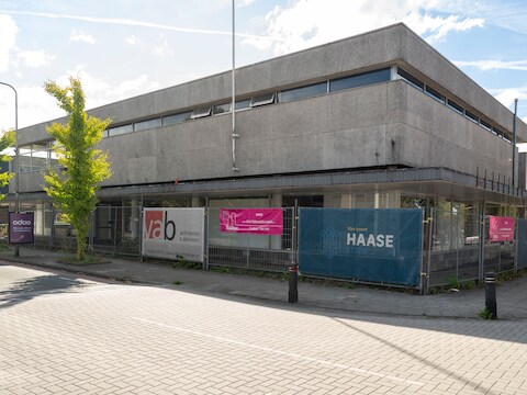 Op de plaats van dit betonnen pand aan de Oranjestraat moet een nieuw appartementencomplex komen. Maar de sloopkogel laat op zich wachten.